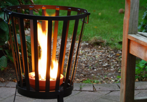 brasero en feu pour pot cire et paille sur terrasse de salon 